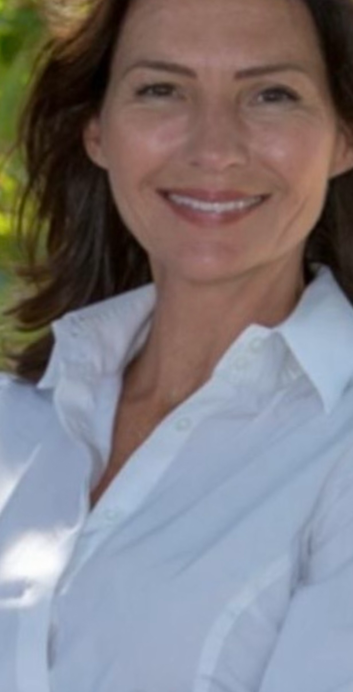 Professional headshot of Heather in London, smiling and wearing a white shirt